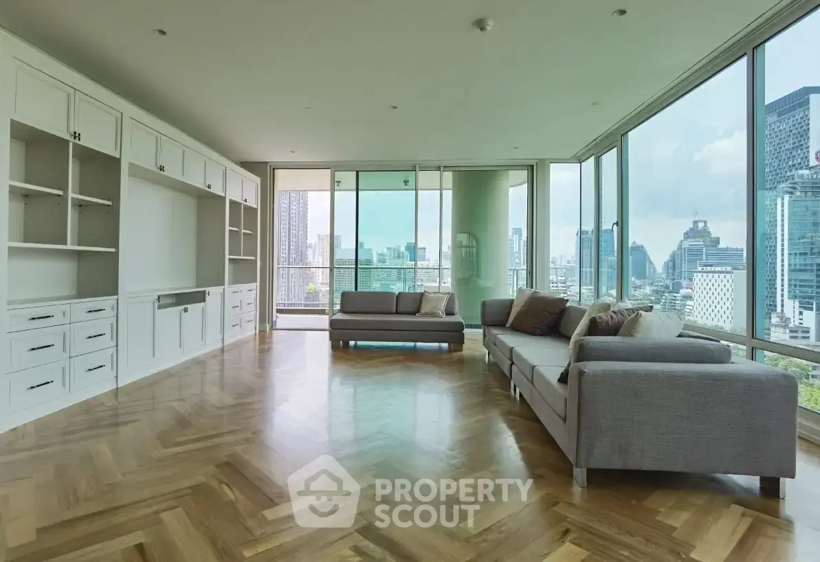 Spacious modern living room with panoramic city views and elegant wooden flooring.