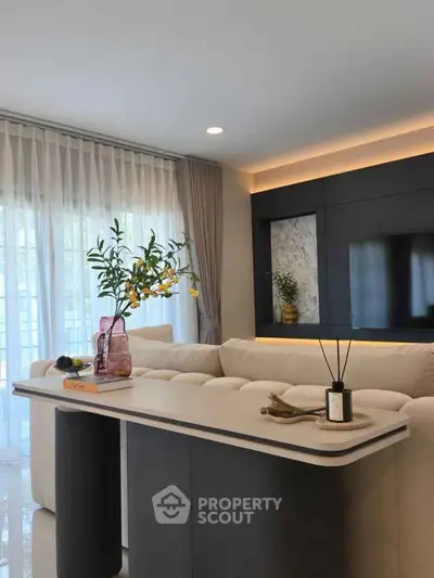 Modern living room with elegant decor and natural light, featuring a stylish sofa and contemporary table.
