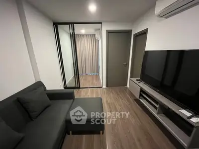 Modern living room with sleek furniture and large TV, perfect for relaxation.