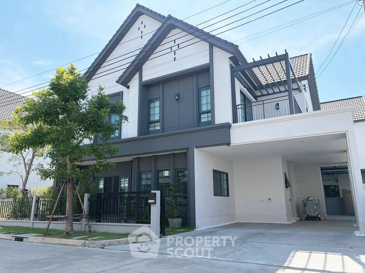 Modern two-story house with spacious driveway and lush greenery
