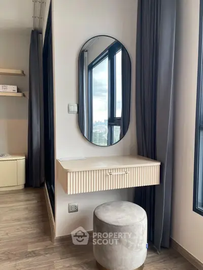 Modern bedroom with stylish vanity and city view from large windows.
