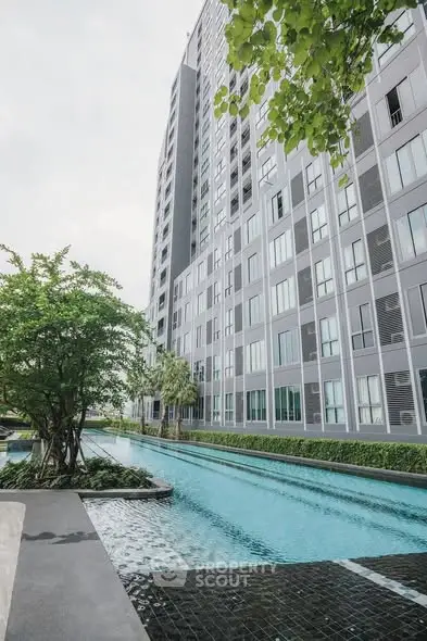 Modern residential building with sleek pool and lush greenery