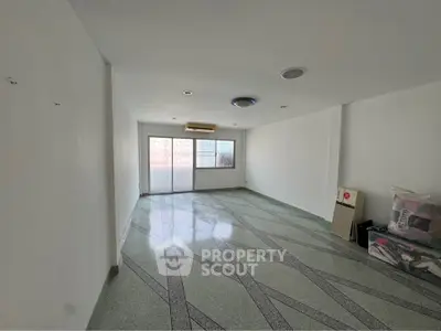 Spacious empty living room with large window and unique floor design