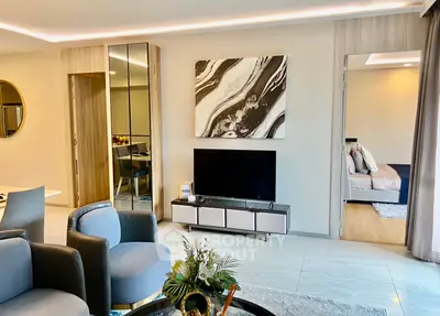 Modern living room with stylish decor and open view into bedroom