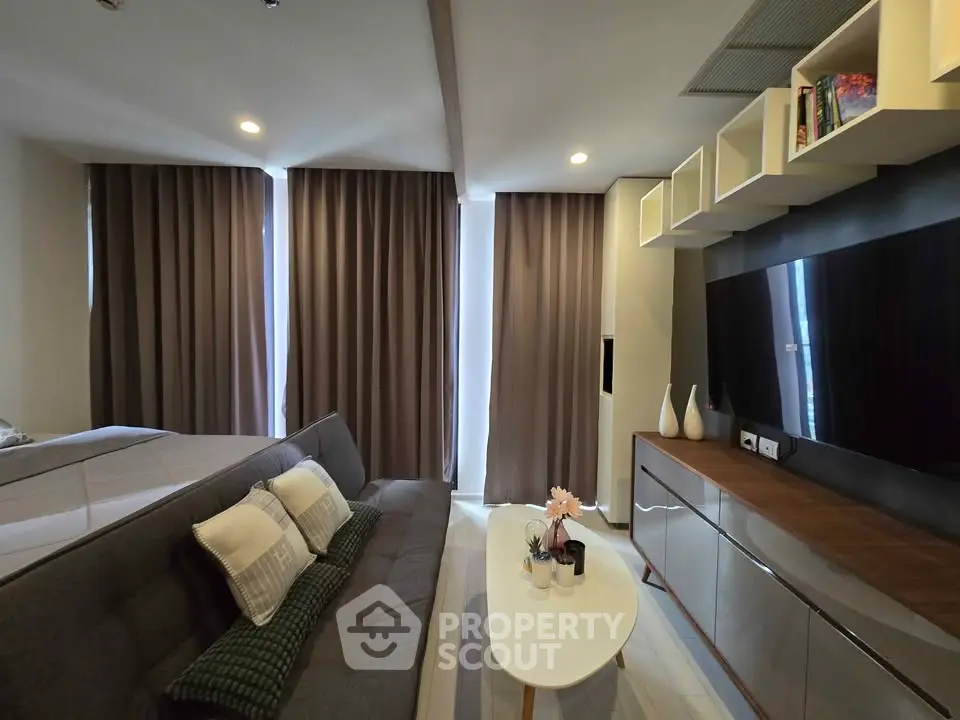 Modern living room with sleek furniture and large TV, perfect for relaxation.