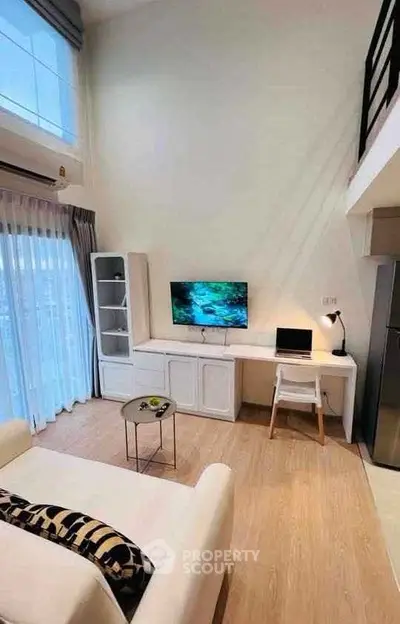Modern living room with high ceiling and stylish decor in a contemporary apartment.