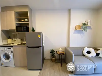 Modern compact living room with kitchen featuring washing machine and fridge