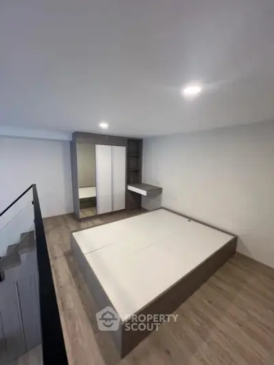 Modern minimalist bedroom with sleek wooden flooring and built-in wardrobe