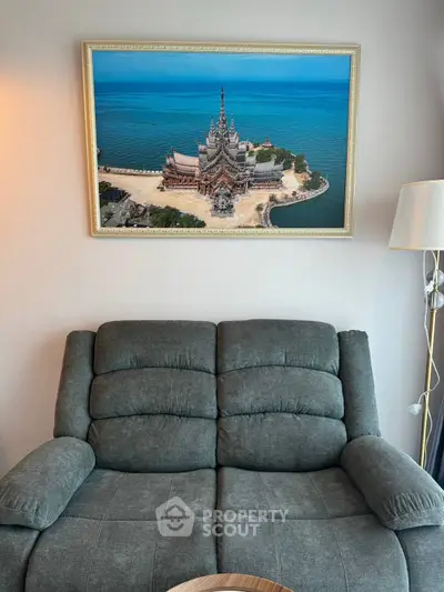 Cozy living room with plush sofa and stunning framed seascape artwork, perfect for relaxation.