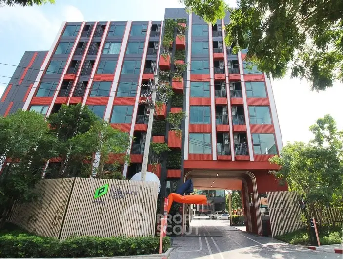 Modern apartment building with vibrant facade and lush greenery