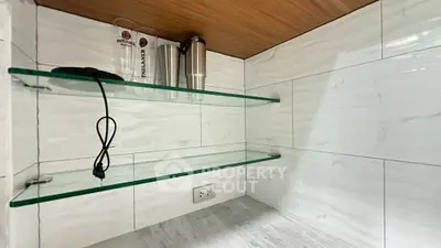 Modern kitchen with glass shelves and marble countertop