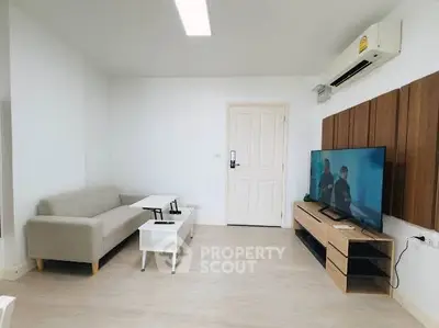 Modern living room with sleek furniture and wall-mounted TV, perfect for relaxation and entertainment.