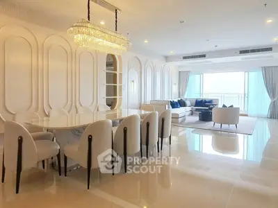 Luxurious open-plan living and dining area with elegant chandelier and modern decor.