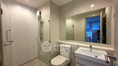 Modern bathroom with sleek shower and elegant fixtures in contemporary apartment.