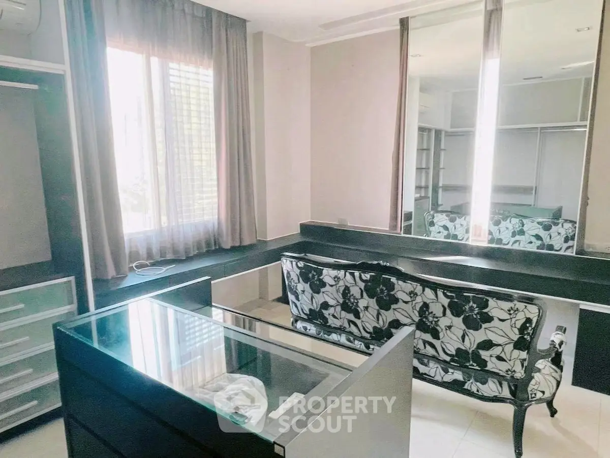 Spacious walk-in closet with elegant seating and ample storage space.