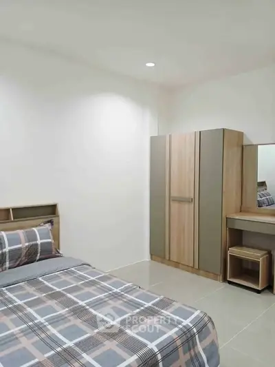 Modern bedroom with stylish furniture and cozy bedding in a minimalist design.