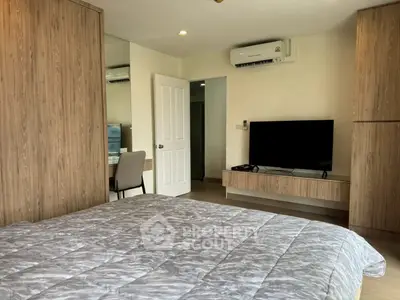 Modern bedroom with stylish wood paneling and wall-mounted TV