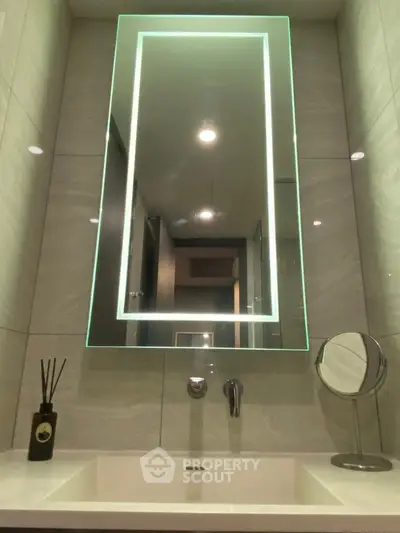 Modern bathroom with illuminated mirror and sleek sink design