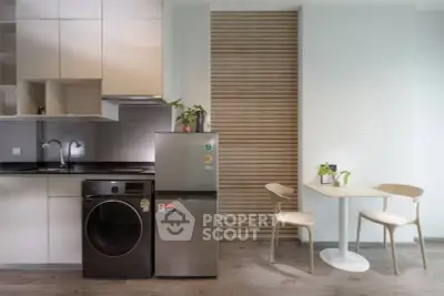 Modern kitchen with sleek appliances and cozy dining area, perfect for urban living.