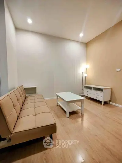 Modern living room with beige sofa, white coffee table, and warm lighting