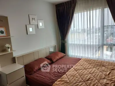 Cozy bedroom with large window and elegant curtains in modern apartment