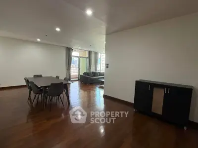 Spacious open-plan living and dining area with modern furniture and wooden flooring.
