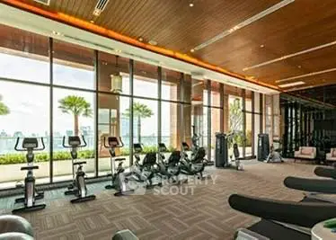 Luxurious gym with panoramic city views and modern fitness equipment.