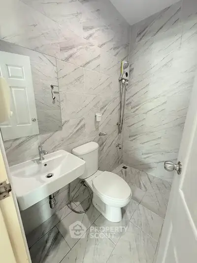 Modern bathroom with sleek white fixtures and marble tile design
