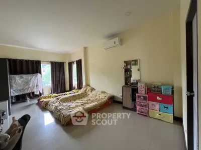 Spacious bedroom with large window and modern air conditioning unit