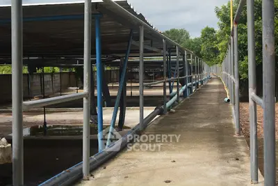 Industrial outdoor space with metal structures and concrete pathways, ideal for commercial use.
