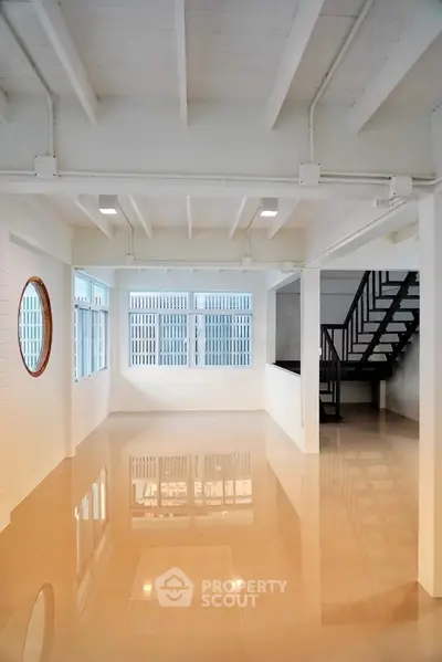 Spacious open-plan interior with glossy floors and modern staircase