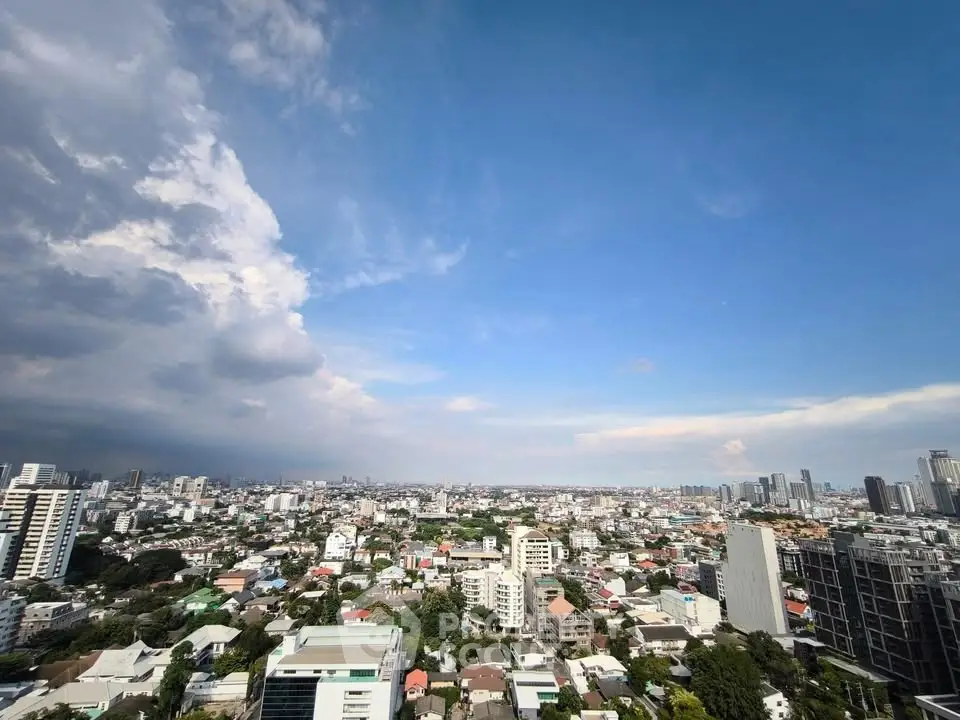Stunning cityscape view from high-rise building showcasing urban skyline under blue sky.
