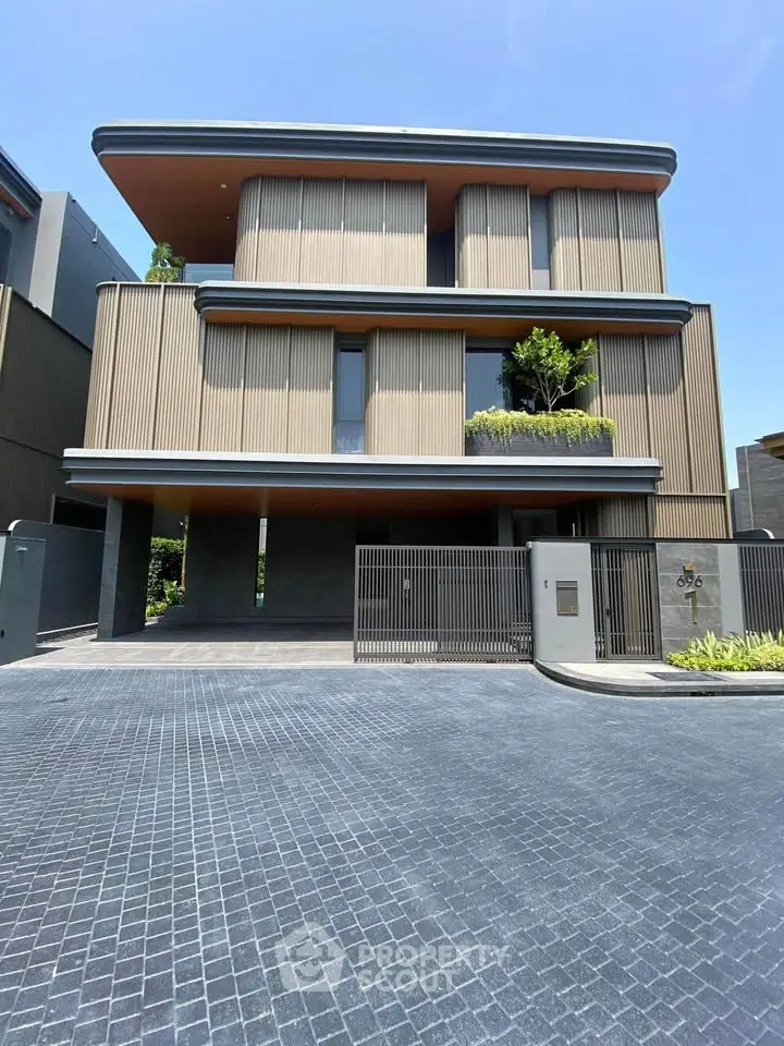 Modern three-story building with sleek design and lush greenery, perfect for luxury living.