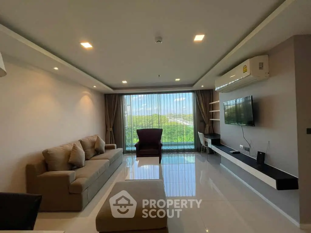 Spacious modern living room with large window and scenic view, featuring comfortable seating and sleek decor.