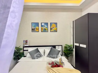 Cozy bedroom with modern decor and stylish artwork, perfect for relaxation.