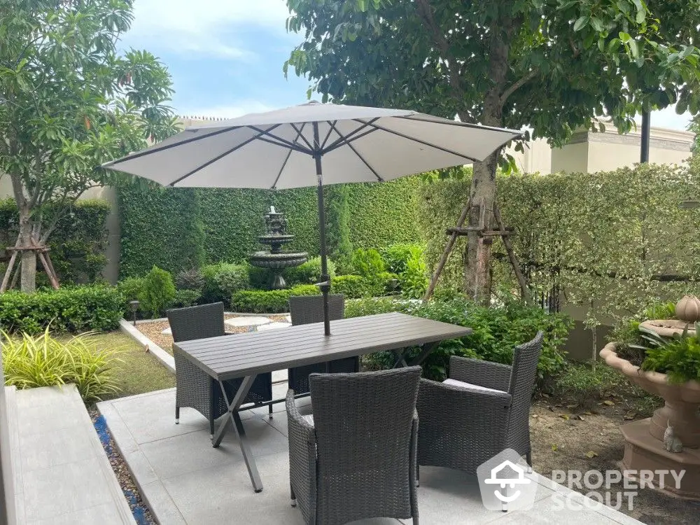 Serene private garden patio with elegant outdoor dining set, lush greenery, and tranquil water feature, perfect for alfresco entertaining.