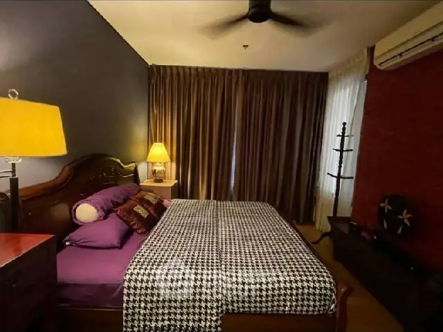 Cozy bedroom with elegant decor and warm lighting, featuring a stylish bed and curtains.