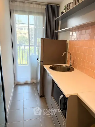Modern compact kitchen with balcony view and sleek appliances