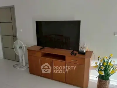 Modern living room with sleek TV stand and decorative flowers
