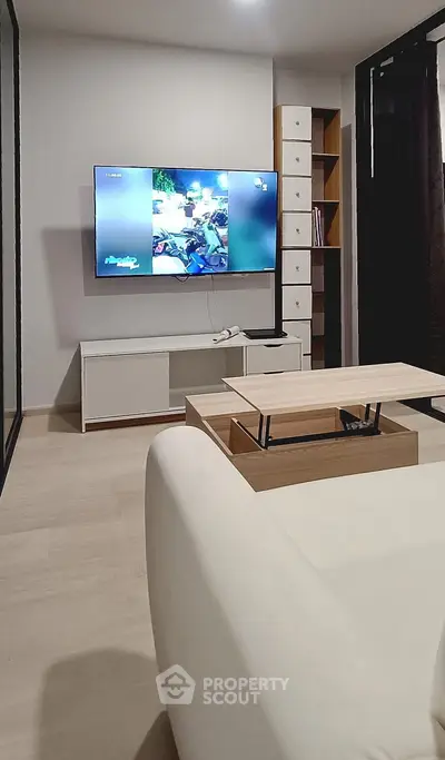 Modern living room with sleek furniture and wall-mounted TV, perfect for relaxation and entertainment.