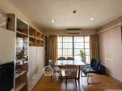 Spacious living room with large windows and modern furniture in a high-rise apartment.