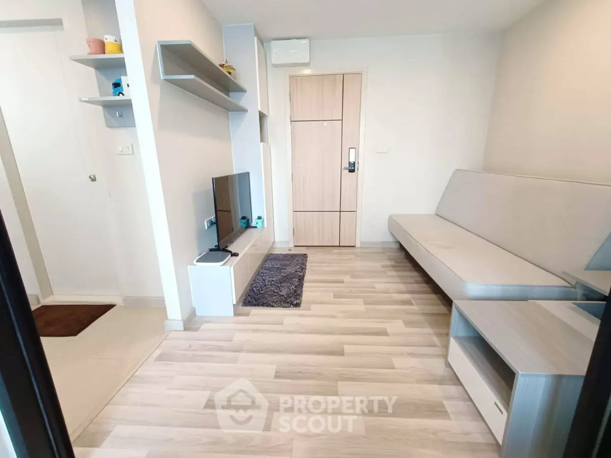 Modern living room with sleek furniture and light wood flooring in a contemporary apartment.