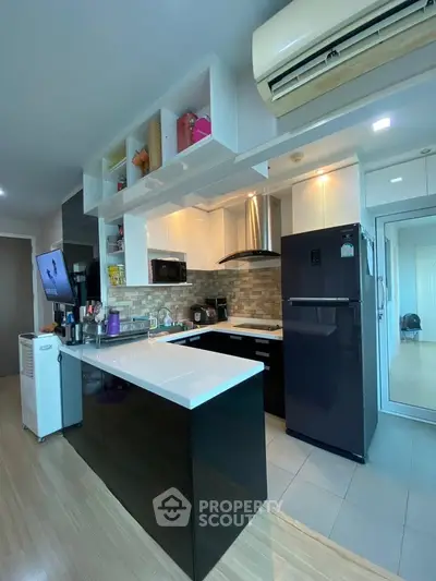 Modern kitchen with sleek black and white cabinetry, featuring a gas stove and spacious countertops.