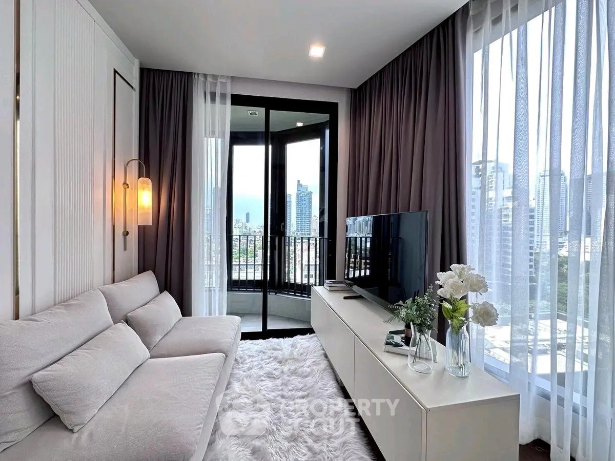 Modern living room with city view, cozy white sofa, and elegant decor in a high-rise apartment.