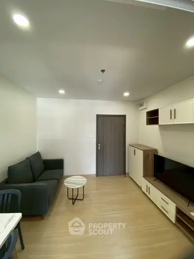 Modern living room with sleek furniture and wooden flooring, perfect for cozy urban living.