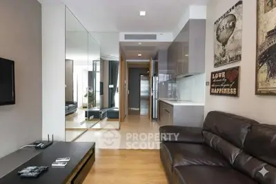 Modern living room with sleek kitchen, leather sofa, and stylish decor in a contemporary apartment.