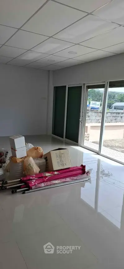 Spacious unfurnished room with large windows and glossy tiled floor, ideal for customization.