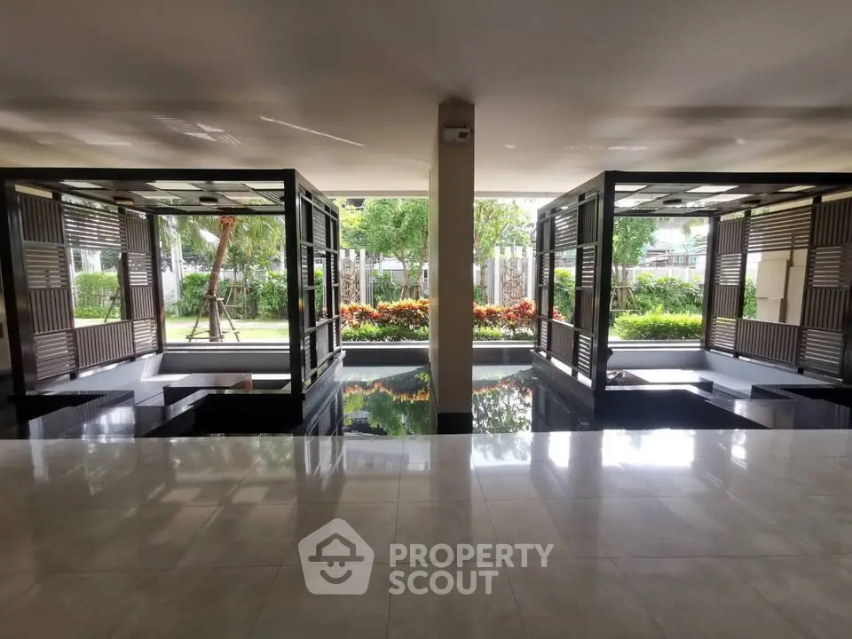 Elegant building entrance with modern design and lush garden view