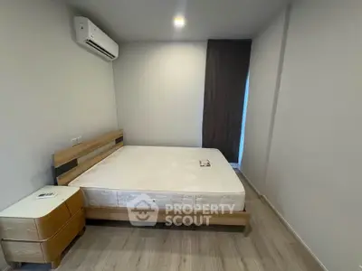 Modern minimalist bedroom with wooden flooring and air conditioning