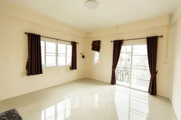 Spacious empty room with large windows and glossy tiled floor